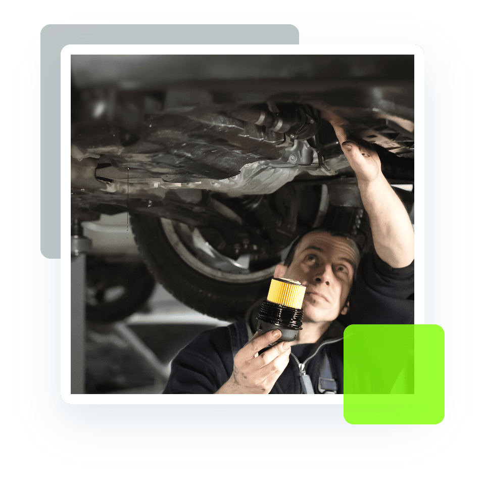 Image of an auto technician holding a flashlight and checking the underside of a car on a lift. Concept image of auto repair and maintenance at Quality Car Care in North Liberty, IA.