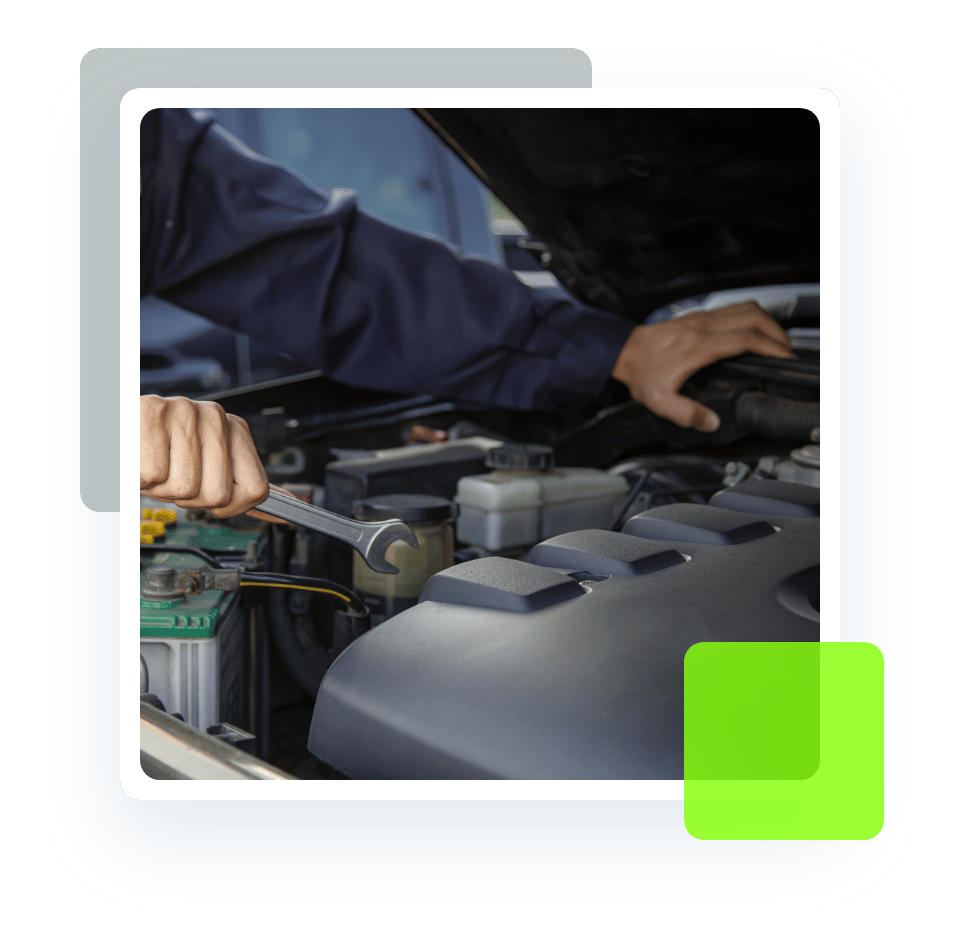 Closeup image of an auto mechanic holding a wrench in the act of fixing a vehicle under the hood. Concept image of auto repair and maintenance at Quality Car Care in North Liberty, IA.