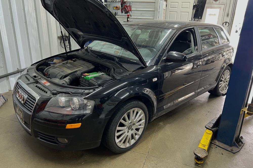 Factory-Recommended Maintenance in North Liberty IA At Quality Car Care. Car with open hood in an auto repair shop
