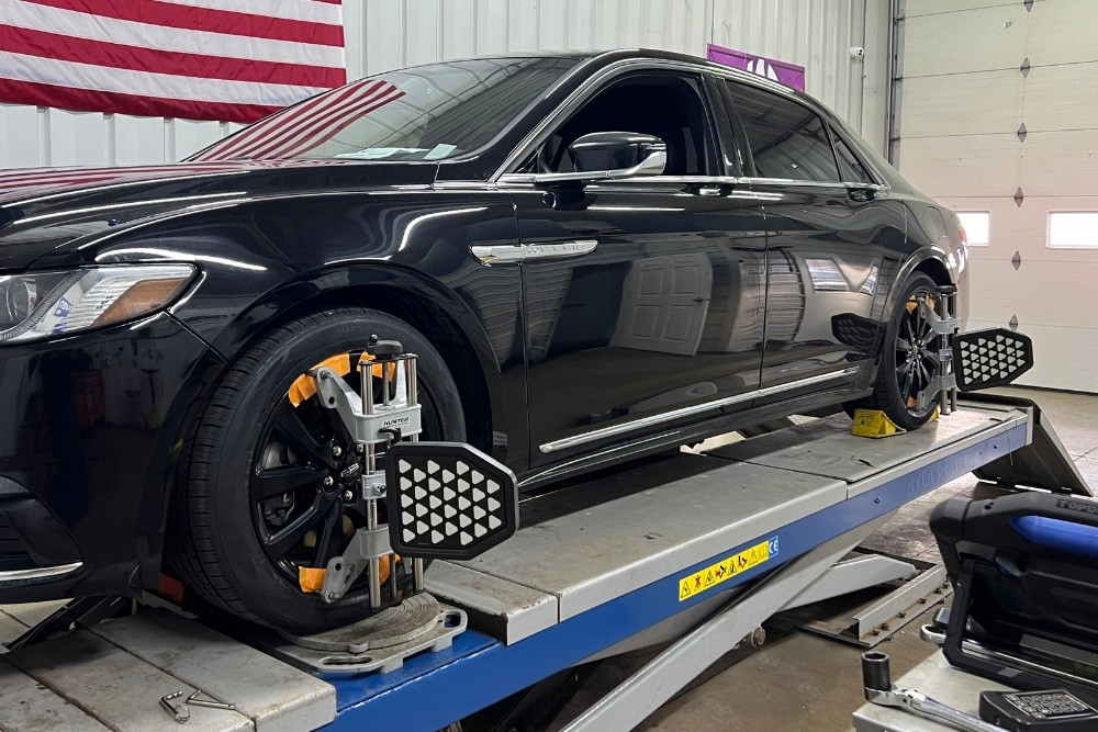 Wheel Alignment Service in North Liberty IA At Quality Car Care. Vehicle raised on alignment lift during wheel alignment inspection